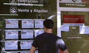 Un hombre mirando un escaparate de pisos. EFE