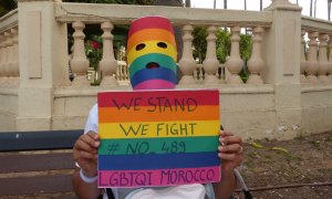 Amer solicitante de asilo LGTBI en Melilla, sostiene un cartel reivindicativo contra el código penal marroquí que criminaliza la homosexualidad.- ROSA SOTO