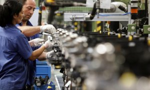 Dos trabajadores de una empresa en el interior de una fábrica. EFE/Archivo