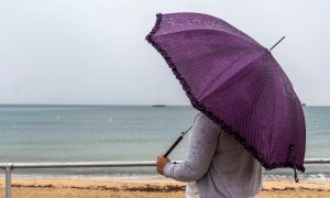 Una mujer se protege de la lluvia este viernes en Palma de Mallorca. EFE/Cati Cladera