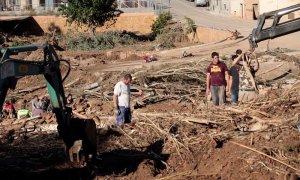 Varios vecinos realizan tareas de limpieza en la población de L'Espluga de Francolí (Tarragona) muy afectada por las riadas de esta semana,mientras los equipos de rescate ha intensificado este viernes la búsqueda de los 4 desaparecidos en las riadas. EFE/