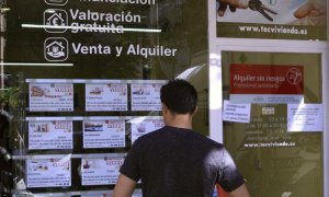 Un hombre observa las ofertas de pisos de una inmobiliaria.-EFE