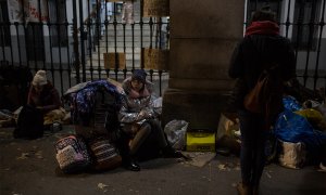 Una niña espera sentada sobre sus maletas a que los trabajadores del Samur Social de Madrid confirme si su familia, procedente de Georgia, tendrá plaza en un albergue para pasar la noche mientras formalizan su solicitud de protección internacional.- JAIRO