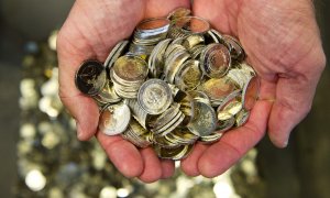 Un hombre sostiene varias monedas de euro. EFE/Archivo