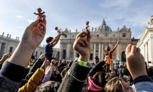 15/12/2019.- Jóvenes muestran figuras del Niño Jesús en la Plaza de San Pedro del Vaticano. / EFE- RICCARDO ANTIMIANI