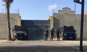 Fachada del CIE custodiada por dos policías, antes de empezar una manifestación.