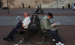 Unos pensionistas leen el periódico sentadados en un banco, en Madrid. REUTERS / Susana Vera