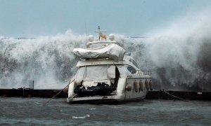 21/01/2020.- Grandes olas sobrepasan el espigón del Puerto Olímpico de Barcelona hundiendo uno de los barcos atracados, este martes en el que Protección Civil ha recomendado evitar los desplazamientos por carretera, sobre todo en el Gironès y Baix Empordà