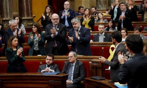 Els diputats i membres del Govern de JxCat aplaudeixen Torra mentre que els d'ERC s'ho miren. EFE / TONI ALBIR