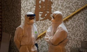 Dos personas, en un edificio de Hong Kong. (JEROME FAVRE | EFE)