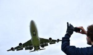 Un hombre fotografía con su teléfono a un avión. (REUTERS/Dylan Martínez)