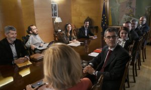 Imagen del comienzo de la reunión de la Comisión Permanente de Coordinación entre PSOE y Unidas Podemos, a la que han acudido entre otros, la portavoz del PSOE en el Congreso, Adriana Lastra (lado derecho de la mesa 3i); la secretaria de Estado de la Agen