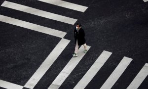 Un surcoreano transita por el popular paso de cebra de Seúl durante la alerta máxima por coronavirus. REUTERS