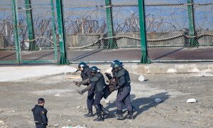 La guardia civil traslada a la fuerza a un migrante para su devolución en caliente a Marruecos tras saltar la valla de Ceuta el 30 de agosto de 2019.- CEAR/José Antonio Sempere