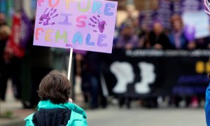 Vista de un menor con un cartel en el que se puede leer "El futuro es femenino" durante la manifestación con motivo del Día Internacional de la Mujer. EFE/ Ana F. Barredo