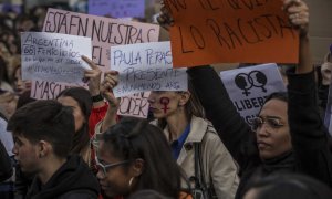 Asistentes a la manifestación feminista de Madrid lucen carteles con nombres de mujeres víctimas de la violencia machista. JAIRO VARGAS