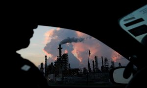 Desde su coche, un policía ve el humo de una refinería industrial de Texas. Reuters/Loren Elliott