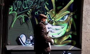 Una persona pasa por una calle de Salamanca en la que han realizado un graffiti con el tema del COVID-19. EFE/J.M.GARCIA