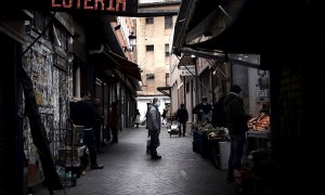 Un hombre espera su turno en una frutería del Mercado de Antón Martín en Madrid. Las colas para comprar en los supermercados se han vuelto parte del paisaje urbano ante el estado de alarma por la pandemia del coronavirus, pero las tiendas de alimentación