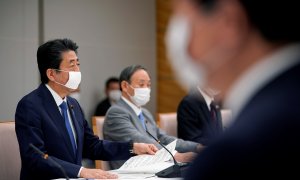 El primer ministro de Japón, Shinzo Abe, con mascarilla, con otros miembros de su gabinete para analizar las medidas frente a la pandemia del coronavirus. REUTERS/Franck Robichon