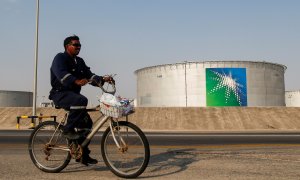 Un trabajador pasa, en bicicleta, cerca de uno de los tanques de almacenamiento de crudo de la petrolera estatal saudí Aramco, en sus instalaciones en  Abqaiq. REUTERS/Maxim Shemetov