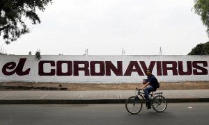 Un ciudadano pedalea con su bicicleta junto a un muro con una pintada que hace referencia al coronavirus. REUTERS/Carlos Jasso