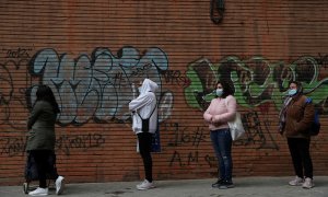 Personas  haciendo cola para recibir alimentos donados por voluntarios de la asociación Vecinos Parque Aluche, en Madrid, durante el estado de alarma por la pandemia del coronavirus. REUTERS / Susana Vera