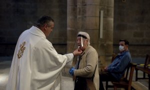 11/05/2020.- Una mujer comulga durante la celebración de misa en el interior de la catedral de Ourense. / EFE - BRAIS LORENZO