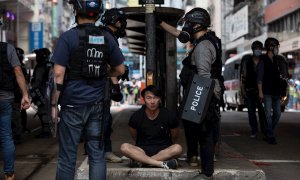 La policía detiene a un manifestante durante una manifestación contra la implementación de la ley de seguridad nacional en Hong Kong. EFE / JEROME FAVRE