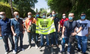 Miembros del Comité de Empresa de Alcoa San Cibrao sujetan un chaleco en el que se lee "Alcoa, Despidos Non", a la salida de la reunión entre el Comité y la directiva de la multinacional estadounidense tras el anuncio del despido colectivo de hasta 534 tr