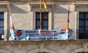 Fachada del Ayuntamiento de un pueblo con una pancarta por la sanidad.