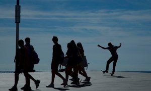 Un grupo de jóvenes caminan por la playa de la Barceloneta. - EFE