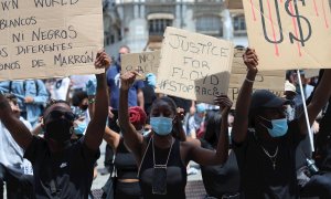 Manifestantes en la Puerta del Sol durante la concentración convocada en Madrid por la Comunidad negra africana y afrodescendiente en España (CNAAE) contra el racismo, tras la muerte del ciudadano afroamericano, George Floyd, durante su detención por la p