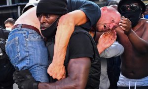 Un hombre que protestaba en Londres por la muerte de George Floyd sostiene a otro que participaba en una marcha contraria al Black Lives Matter.  REUTERS/Dylan Martinez