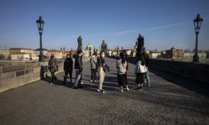 Turistas japoneses con mascarilla en el Puerte de Carlos, de Praga, en las primeras semanas de la pandemia por coronavirus. AFP/Michal Cizek