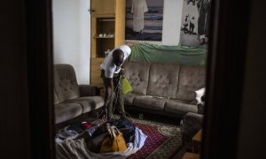 Samba, senegalés de 28 años, muestra el el salón de su casa de Lavapiés la manta con los bolsos que no ha podido vender en la calle durante el confinamiento decretado por el coronavirus.-  JAIRO VARGAS