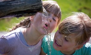 Dos niños beben agua en una fuente. Imagen de archivo / Pixabay.