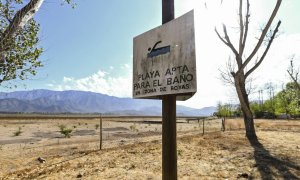 "Playa apta para el baño", reza un cartel de un lago chileno desaparecido por la sequía. AFP/Martín Bernetti