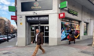 Pie de Foto: Dos personas pasan junto a un salón de juegos de Madrid el mismo día en el que se ha anunciado que el control físico de acceso a casas de apuestas será obligatorio en los 678 locales de la Comunidad de Madrid, en Madrid (España) a 18 de febre