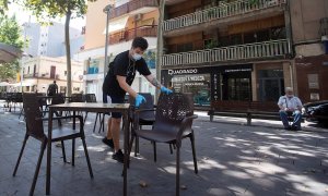 30/07/2020.- Un camarero prepara las mesas de un restaurante del centro de Gavà (Barcelona), una de las poblaciones, junto a Castelldefels, en las que el Govern ha ampliado las restricciones que afectan a Barcelona por el aumento de contagios de covid-19