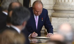 Juan Carlos I firma su abdicación, en una ceremonia en la Sala de Columnas del Palacio Real de Madrid, el 18 de junio de 2014. AFP/GERARD JULIEN