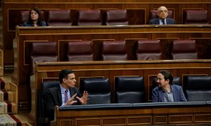 El presidente del Gobierno, Pedro Sánchez, conversa con el vicepresidente segundo, Pablo Iglesias,  durante una sesión de control al Gobierno en el Congreso de los Diputados. E.P./Pool