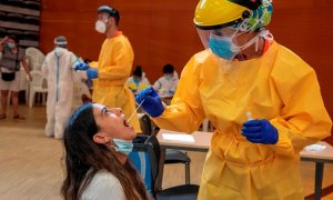 Una joven es atendida por un profesional sanitario en un Centro Cívico de barrio de Balàfia LLeida, donde el departamento de Salud realiza cribados masivos de PCR. EFE/ Ramon Gabriel/Archivo