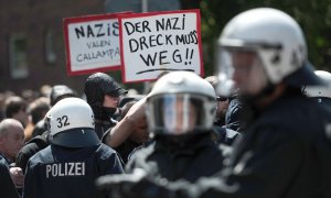 Manifestantes sostienen carteles para protestar contra una manifestación extremistas en Hamburgo. AFP / CHRISTIAN CHARISIUS