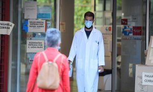 Un sanitario recibe a una paciente termómetro en mano en el centro de salud Federica Montseny en el distrito de Puente de Vallecas en Madrid.-EFE