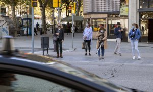 Diferents dones esperant per creuar la Gran Via de de Barcelona. Bru Aguiló