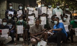 Un grupo de migrantes malienses muestra su expediente de devolución en una plaza de Las Palmas de Gran Canaria, cerca del centro de acogida en el que esperan más de un mes después de llegar en patera a la isla.- JAIRO VARGAS