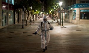 Un operario municipal realiza labores de desinfección, en la calle del Paseo de Ourense, en la madrugada de este martes. El Gobierno de España ha decretado el estado de alarma desde las 11pm. a las 6 am. para todo el territorio nacional, con posibilidad d