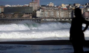 Una mujer observa las olas desde el paseo marítimo de A Coruña.