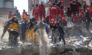 Trabajadores de rescate buscan sobrevivientes en un edificio derrumbado en el distrito de Bayrakli en Izmir, Turquía.